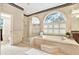Bright bathroom featuring a soaking tub with jets, glass shower, and large arched window at 407 S West Shore Blvd, Tampa, FL 33609