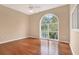 Spacious bedroom with hardwood floors, ceiling fan, and large arched window at 407 S West Shore Blvd, Tampa, FL 33609