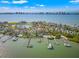 Breathtaking aerial view of a waterfront estate featuring a pool, private dock, and lush landscaping at 436 St Andrews Dr, Belleair, FL 33756
