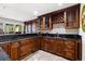 Elegant bar with rich wood cabinetry, granite countertops, and mosaic tile accents at 436 St Andrews Dr, Belleair, FL 33756