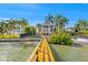 Elegant waterfront home with a private dock surrounded by lush landscaping and mature palm trees at 436 St Andrews Dr, Belleair, FL 33756