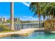 A beautiful pool and spa with a stone waterfall and views of the water and city at 436 St Andrews Dr, Belleair, FL 33756