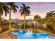 Stunning waterfront pool with lush tropical landscaping and waterfall feature, perfect for relaxation at 436 St Andrews Dr, Belleair, FL 33756