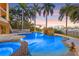 Stunning pool featuring a waterfall, palm trees and nearby city views for outdoor relaxation and entertainment at 436 St Andrews Dr, Belleair, FL 33756