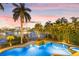 A tranquil pool with a waterfall and palm trees, with gorgeous water and city views at 436 St Andrews Dr, Belleair, FL 33756