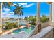 Gorgeous waterfront pool and spa featuring a waterfall and scenic water views from a private balcony at 436 St Andrews Dr, Belleair, FL 33756