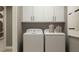 Efficient laundry room with a side-by-side washer and dryer, and upper cabinets for ample storage at 4511 S Manhattan Ave # 31, Tampa, FL 33611