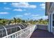 Open balcony with white railings overlooking palm trees and the pool area at 5616 Seagrass Pl, Apollo Beach, FL 33572
