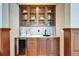 Convenient bar area featuring custom cabinets, wine fridge, and sink, perfect for entertaining guests at 5616 Seagrass Pl, Apollo Beach, FL 33572