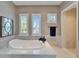 Bright bathroom with a large soaking tub, white shutters, and natural light at 5616 Seagrass Pl, Apollo Beach, FL 33572