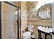 Elegant bathroom with glass-enclosed shower, toilet, and unique patterned wallpaper at 5616 Seagrass Pl, Apollo Beach, FL 33572