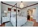 Spacious bedroom featuring a four-poster bed, chandelier, and hardwood floors at 5616 Seagrass Pl, Apollo Beach, FL 33572