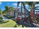 Landscaped exterior with a screened lanai, trees, and well-manicured lawn at 5616 Seagrass Pl, Apollo Beach, FL 33572