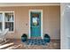 Charming front porch with blue door, brick flooring, rocking chair and potted plants at 5616 Seagrass Pl, Apollo Beach, FL 33572