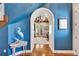 Stylish hallway featuring hardwood floors, arched doorway and elegant coastal décor at 5616 Seagrass Pl, Apollo Beach, FL 33572