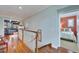 Upstairs hallway with hardwood floors, a living room view, and a bedroom at 5616 Seagrass Pl, Apollo Beach, FL 33572