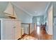 Light-filled hallway features hardwood floors, white trim, and a charming nautical decor at 5616 Seagrass Pl, Apollo Beach, FL 33572