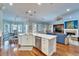 Open kitchen and living area featuring an island with quartz countertops and stainless steel dishwasher at 5616 Seagrass Pl, Apollo Beach, FL 33572