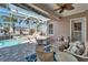 Covered lanai with wicker furniture set overlooking sparkling pool and lush landscaping at 5616 Seagrass Pl, Apollo Beach, FL 33572