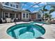 View of the screened pool and spa with view of the home's outdoor patio at 5616 Seagrass Pl, Apollo Beach, FL 33572
