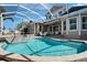 Relaxing screened pool with an attached spa, and a view of the two-story home at 5616 Seagrass Pl, Apollo Beach, FL 33572