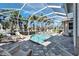 A screened pool area with a spa, outdoor seating, and tiled deck at 5616 Seagrass Pl, Apollo Beach, FL 33572
