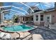 View of the screened pool, spa, and home with outdoor seating and balconies at 5616 Seagrass Pl, Apollo Beach, FL 33572