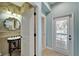 Stylish powder room with bamboo wallpaper, decorative mirror, and tiled floors at 5616 Seagrass Pl, Apollo Beach, FL 33572