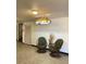 Hallway with two chairs and a sign that reads Cornell under an art deco style lighting fixture at 5750 80Th N St # A106, St Petersburg, FL 33709