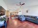 Living room featuring hardwood floors, a ceiling fan, and an open view of the kitchen at 5827 Fieldspring Ave, New Port Richey, FL 34655