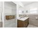 Bathroom features a double sink vanity, wood cabinets, a large mirror, and ample shelving at 6103 Anna Ave, Gibsonton, FL 33534