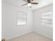 Bedroom featuring a ceiling fan, neutral carpet, window with blinds, and white walls at 6103 Anna Ave, Gibsonton, FL 33534