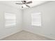 Cozy bedroom features a ceiling fan, neutral carpet, and two windows offering ample natural light at 6103 Anna Ave, Gibsonton, FL 33534
