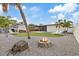 Landscaped backyard featuring a fire pit, lounging area, and manicured gravel, great for outdoor gatherings at 6339 S Lansdale Cir, Tampa, FL 33616