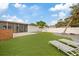 Private backyard with artificial turf, lounge chairs and screened in porch, perfect for outdoor relaxation and recreation at 6339 S Lansdale Cir, Tampa, FL 33616