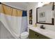Cozy bathroom features a modern sink, decorative art, and an earth-toned shower curtain at 6339 S Lansdale Cir, Tampa, FL 33616