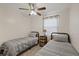 Cozy bedroom features twin beds, ceiling fan, and neutral decor at 6339 S Lansdale Cir, Tampa, FL 33616