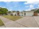 Inviting single-story home with a well-kept lawn, modern siding, an eye-catching teal door and a driveway at 6339 S Lansdale Cir, Tampa, FL 33616
