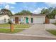 Charming home featuring a vibrant teal door and a well-maintained front lawn, perfect curb appeal at 6339 S Lansdale Cir, Tampa, FL 33616