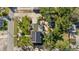 Aerial view shows a home equipped with solar panels and a backyard featuring a pool and lush landscaping at 681 Jasmine S Way, St Petersburg, FL 33705