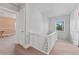 Upstairs hallway with white railing, and view of the window at 681 Jasmine S Way, St Petersburg, FL 33705