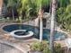 Aerial view of the beautiful pool area featuring a rock waterfall, lush landscaping, and relaxing spa at 681 Jasmine S Way, St Petersburg, FL 33705