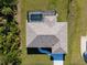 Overhead drone shot of a house with a screened-in swimming pool, well-kept lawn, and lengthy private driveway at 7235 Peacock Ln, Englewood, FL 34224