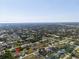 An aerial view of a residential neighborhood shows rooftops, and roads stretching to the distant horizon, with trees in between at 7235 Peacock Ln, Englewood, FL 34224