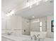 Bathroom features a marble countertop, double sinks, a glass shower, and modern light fixture at 7235 Peacock Ln, Englewood, FL 34224