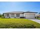Charming single-story home with a well-manicured lawn, attached garage, and neutral-toned exterior paint at 7235 Peacock Ln, Englewood, FL 34224