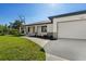 Well-manicured lawn and a concrete walkway to the front door and attached two car garage at 7235 Peacock Ln, Englewood, FL 34224