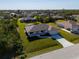 The house's exterior highlighting the green lawn, long driveway, and surrounding serene neighborhood at 7235 Peacock Ln, Englewood, FL 34224