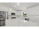 Bright kitchen with stainless appliances, white cabinets, and tile backsplash at 7235 Peacock Ln, Englewood, FL 34224