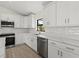 Kitchen showcasing stainless appliances, white cabinets, and subway tile backsplash at 7235 Peacock Ln, Englewood, FL 34224